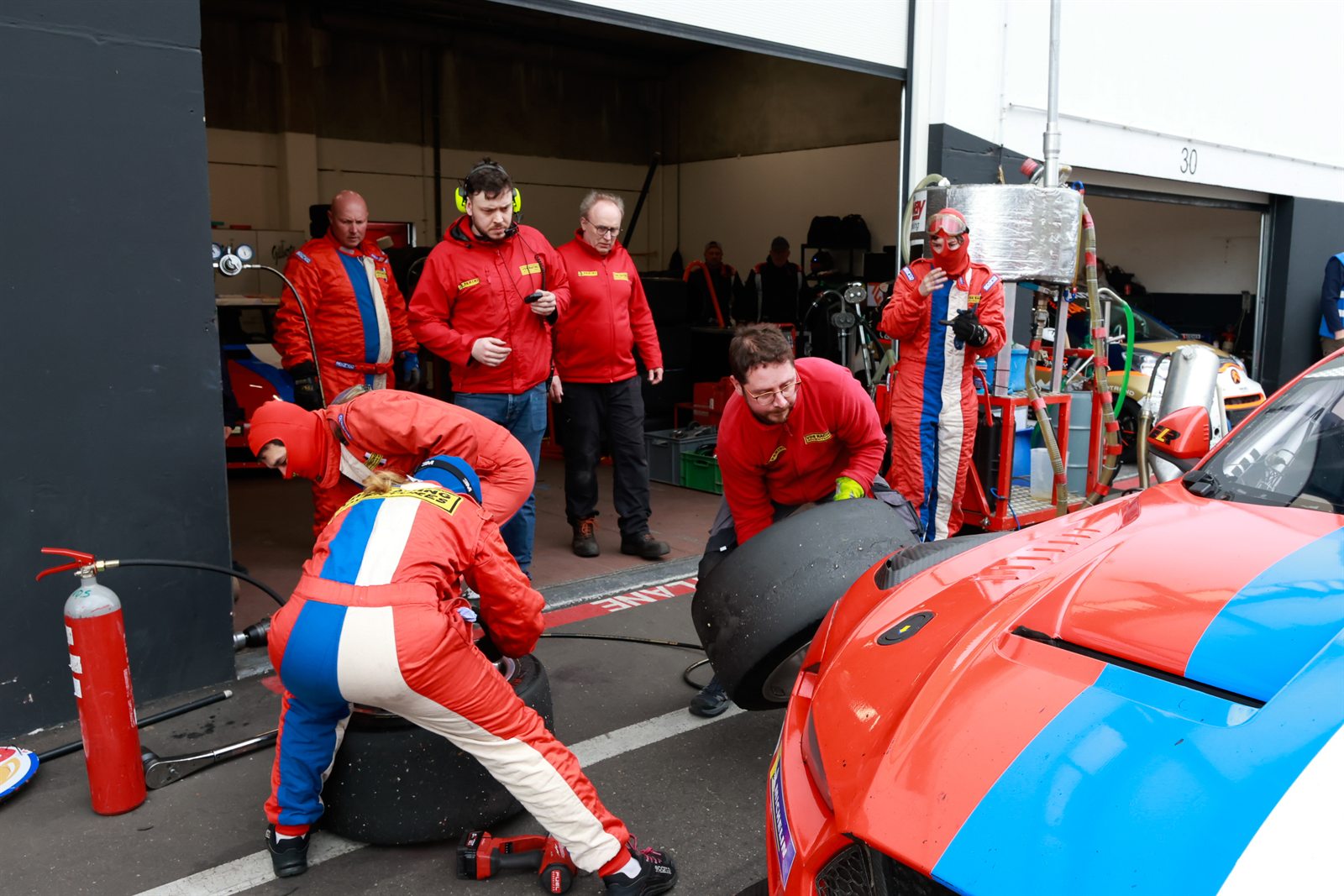 Paddock de Zolder, mecaniciens au travail et moments entre equipiers
