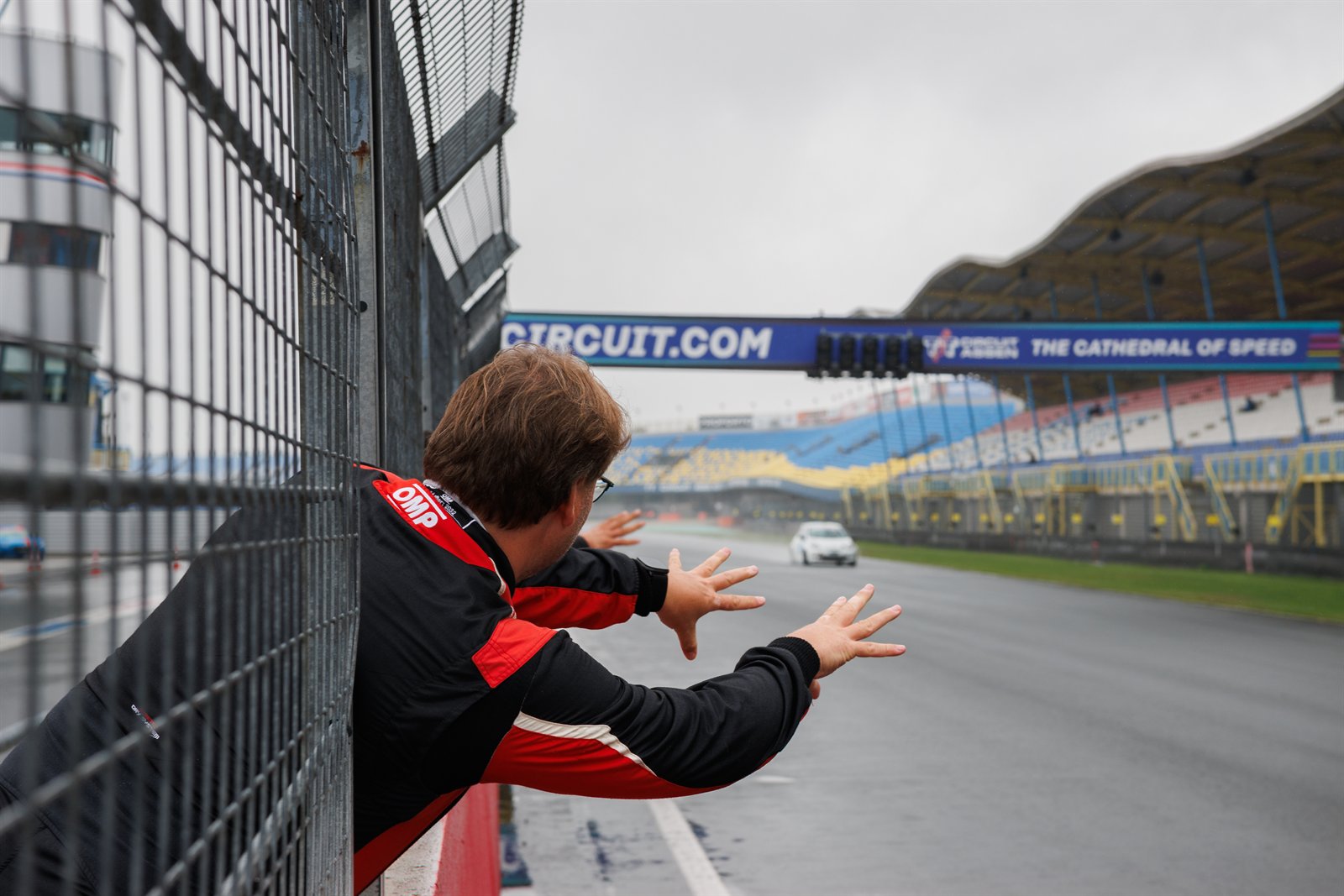 TT Circuit Assen, essais du vendredi, equipier penche au-dessus du muret qui fait signe au pilote